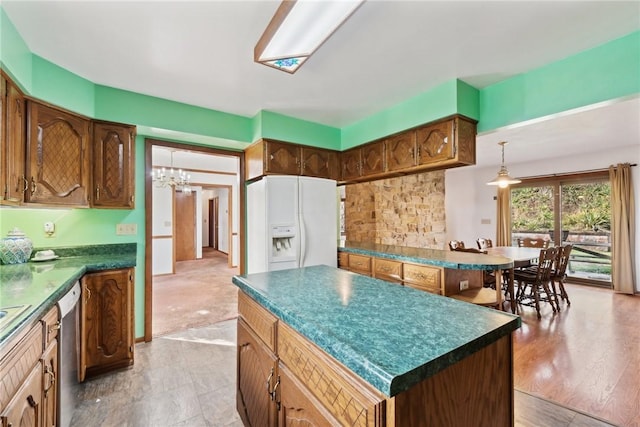 kitchen with dishwasher, a center island, white refrigerator with ice dispenser, light hardwood / wood-style flooring, and a notable chandelier