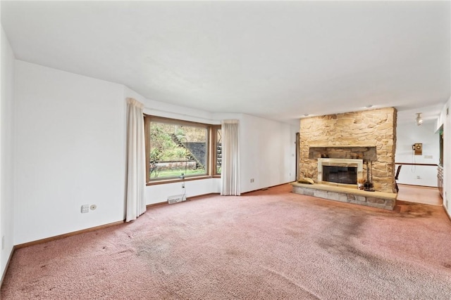 unfurnished living room featuring carpet flooring and a stone fireplace