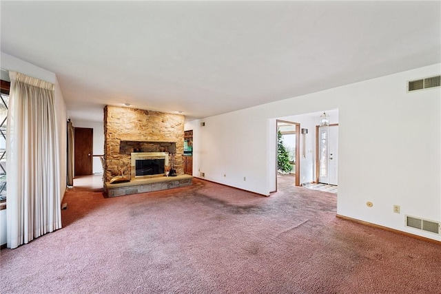 unfurnished living room with carpet flooring and a stone fireplace