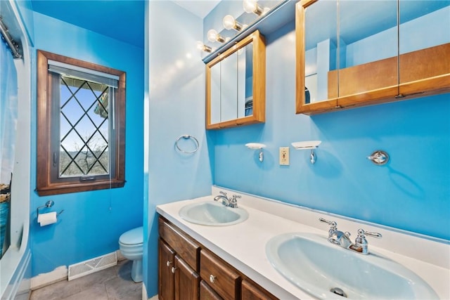 bathroom featuring tile patterned flooring, vanity, and toilet