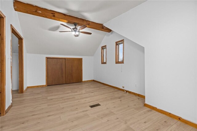 additional living space with ceiling fan, vaulted ceiling with beams, and light wood-type flooring