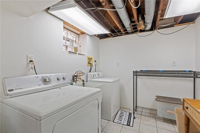 laundry area with sink, washing machine and dryer, and light tile patterned floors