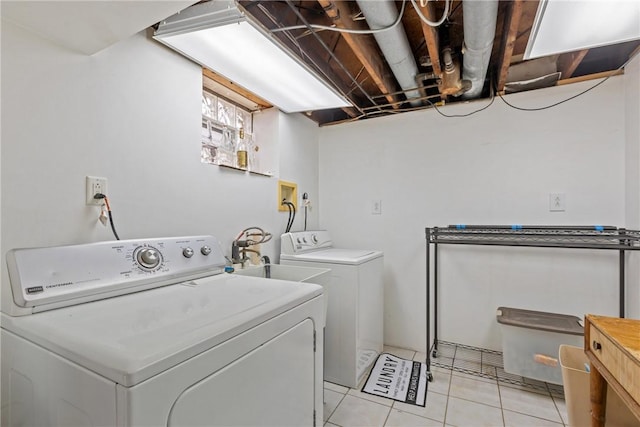 laundry room featuring washing machine and dryer, sink, and light tile patterned floors