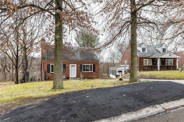 view of front of property with a sunroom and a front yard