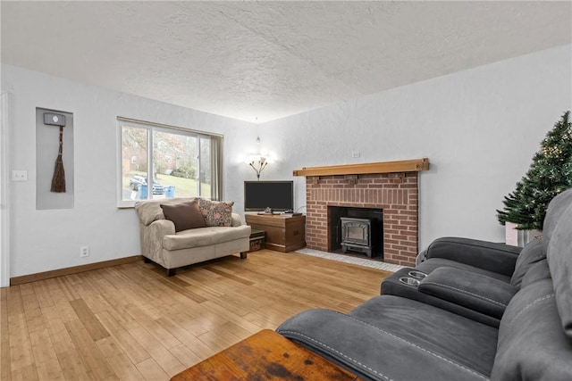 living room featuring hardwood / wood-style flooring, a textured ceiling, and a wood stove