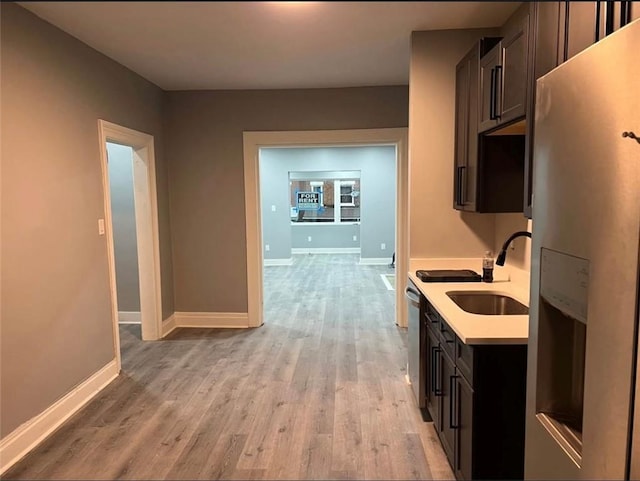 kitchen with dishwasher, sink, light hardwood / wood-style flooring, dark brown cabinetry, and fridge with ice dispenser