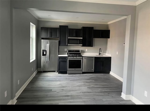 kitchen featuring light hardwood / wood-style floors, sink, ornamental molding, and stainless steel appliances