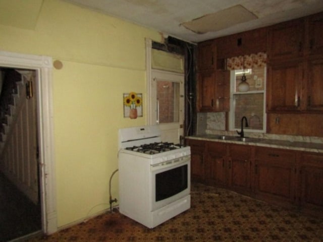 kitchen featuring white gas range and sink