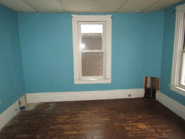 unfurnished room featuring a paneled ceiling and dark hardwood / wood-style flooring