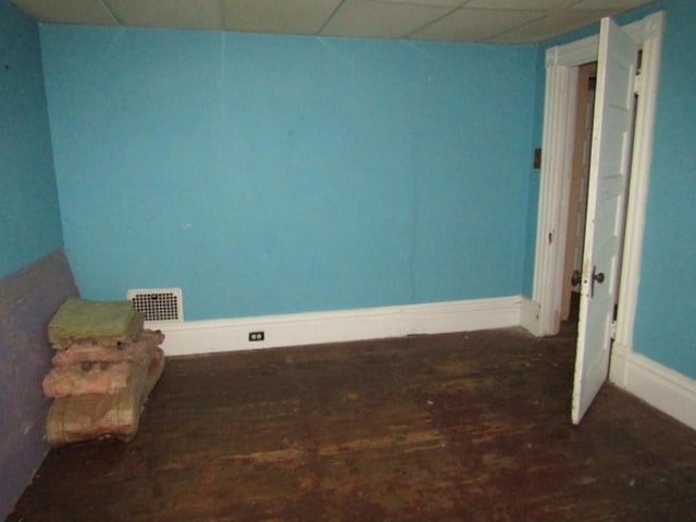 unfurnished room featuring a paneled ceiling and dark wood-type flooring