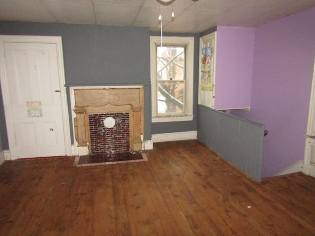 unfurnished living room with a paneled ceiling, ceiling fan, and dark hardwood / wood-style floors