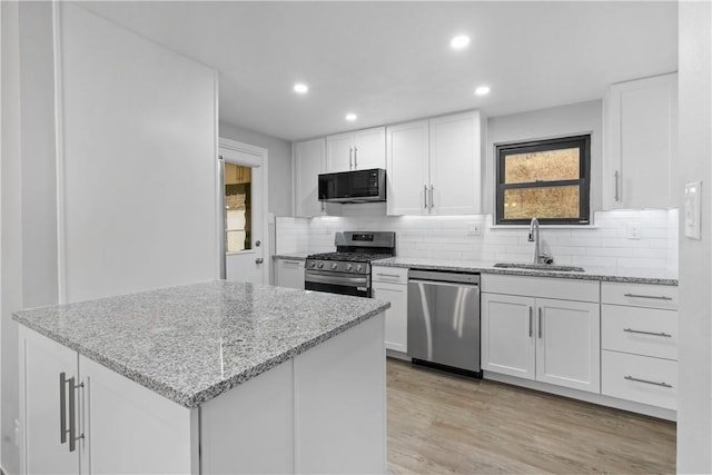 kitchen featuring white cabinets, light stone countertops, sink, and appliances with stainless steel finishes