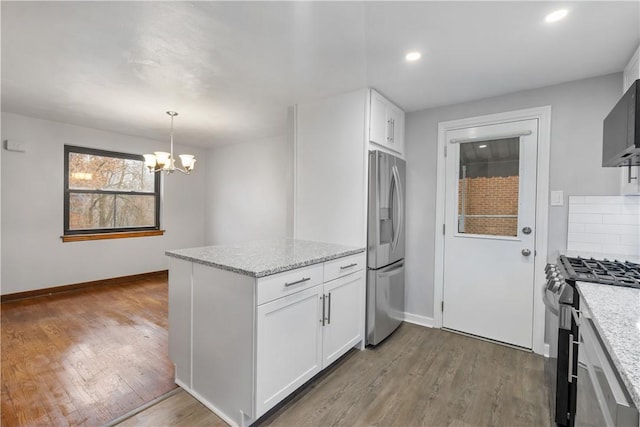 kitchen with white cabinets, appliances with stainless steel finishes, and light stone counters