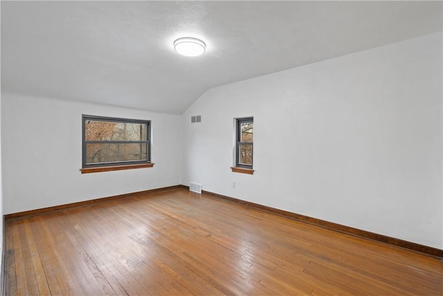 additional living space featuring hardwood / wood-style floors and vaulted ceiling