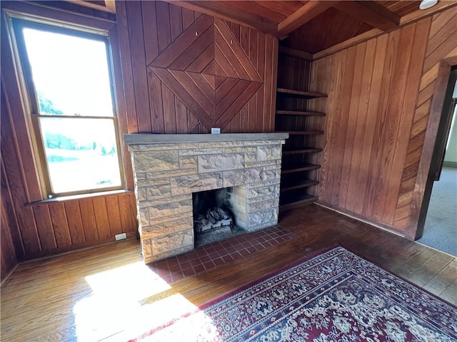 unfurnished living room featuring a healthy amount of sunlight and wooden walls