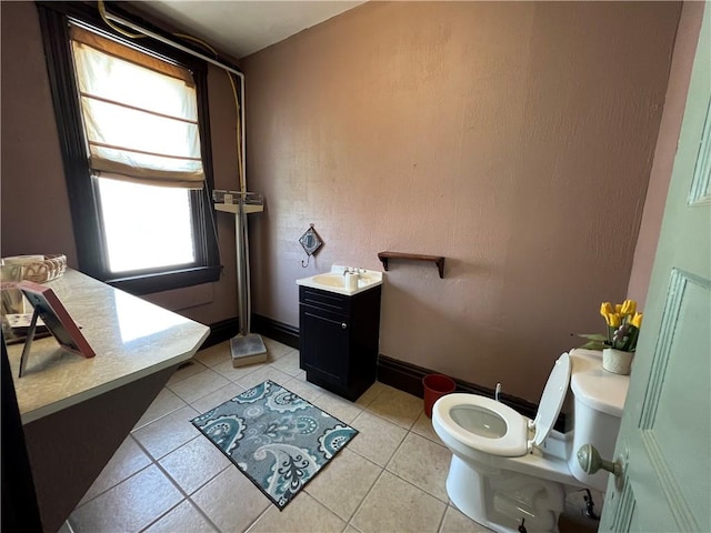 bathroom featuring tile patterned flooring, vanity, toilet, and a wealth of natural light