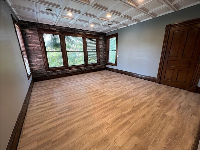 empty room featuring beamed ceiling, light hardwood / wood-style floors, and coffered ceiling