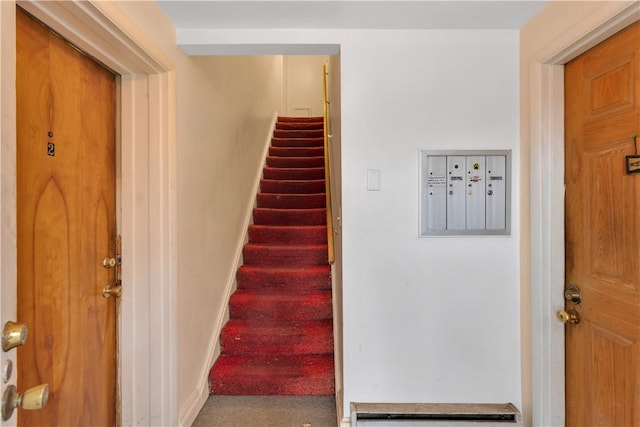 stairs with carpet flooring and mail boxes