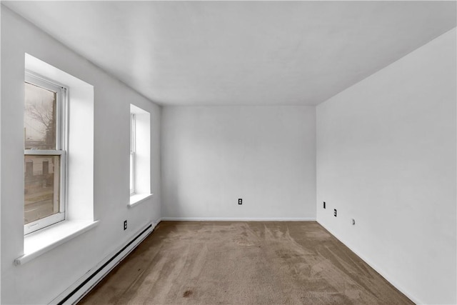 empty room with light colored carpet and a baseboard heating unit