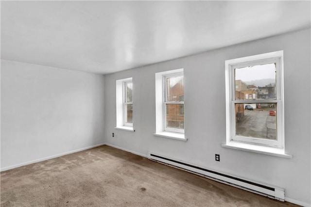 carpeted spare room with a baseboard heating unit