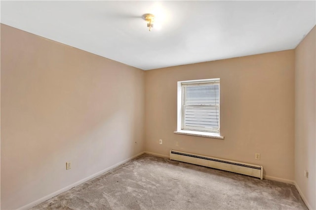 carpeted spare room featuring baseboard heating