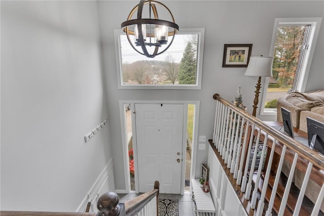 foyer entrance featuring tile patterned floors, a towering ceiling, and a chandelier