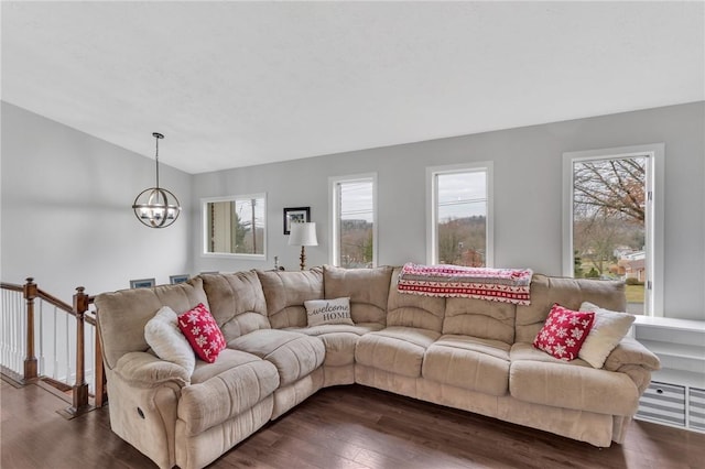 living room with a notable chandelier and dark wood-type flooring