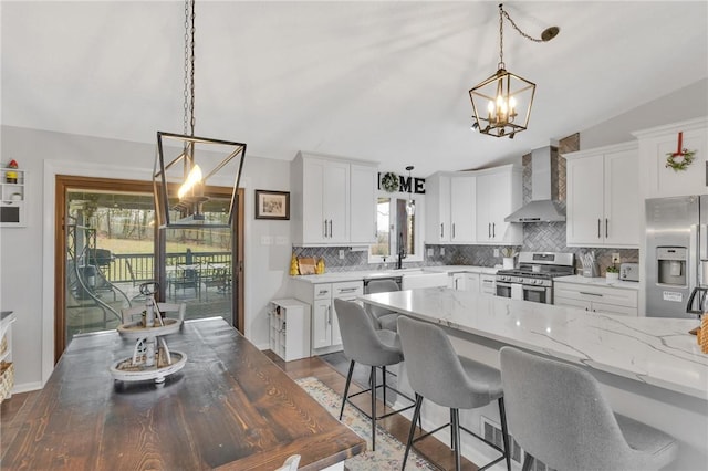 kitchen with white cabinets, appliances with stainless steel finishes, a wealth of natural light, and wall chimney exhaust hood