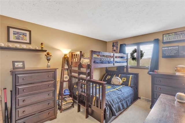 bedroom with light colored carpet and a textured ceiling