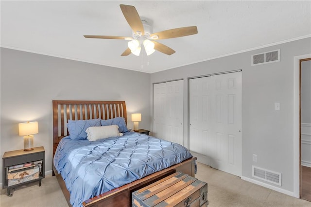 bedroom featuring ceiling fan, crown molding, light carpet, and multiple closets