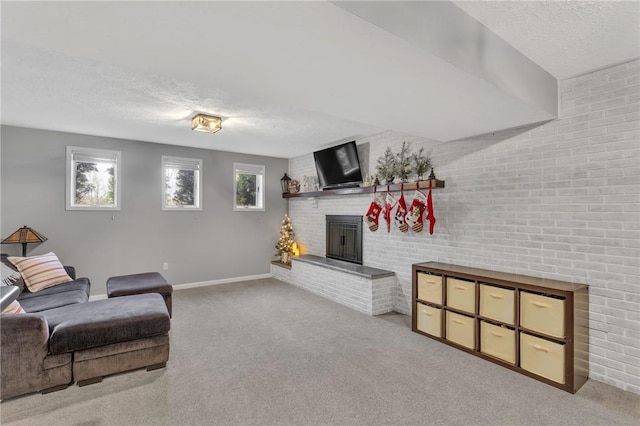 carpeted living room with a textured ceiling, brick wall, and a brick fireplace