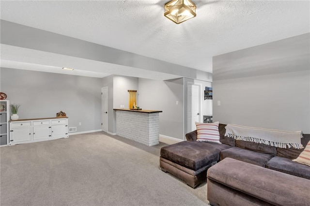 carpeted living room with bar area and a textured ceiling