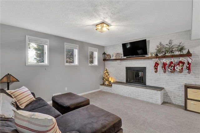 carpeted living room with a fireplace, plenty of natural light, brick wall, and a textured ceiling