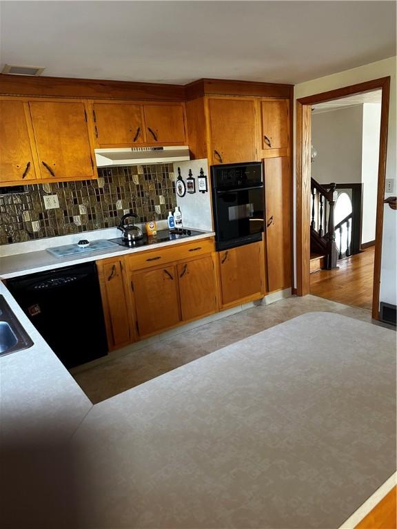 kitchen featuring sink, tasteful backsplash, and black appliances