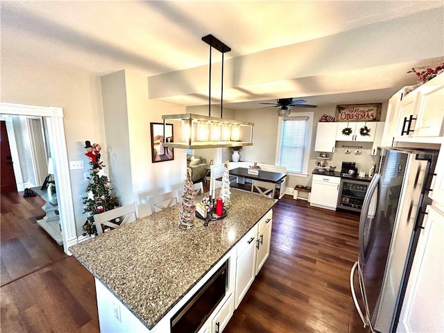 kitchen with stainless steel refrigerator, a kitchen island, dark hardwood / wood-style floors, pendant lighting, and white cabinets