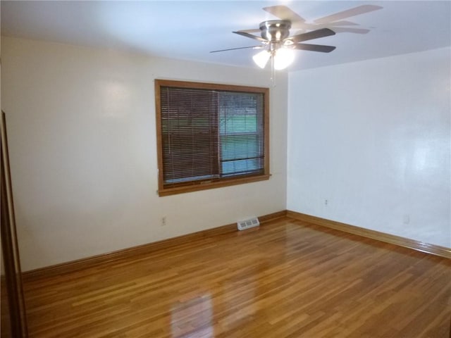 spare room with hardwood / wood-style floors and ceiling fan