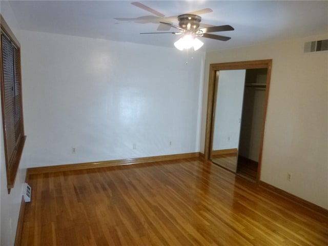 unfurnished bedroom with hardwood / wood-style floors, a closet, and ceiling fan