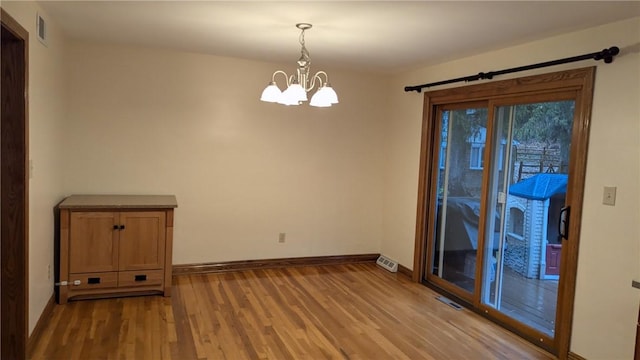 empty room featuring hardwood / wood-style floors and a notable chandelier