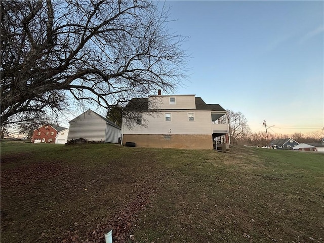 back house at dusk featuring a yard