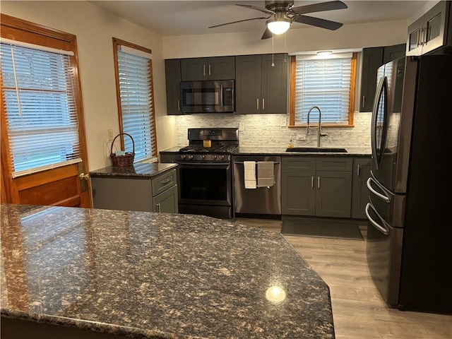 kitchen featuring sink, black appliances, plenty of natural light, and light wood-type flooring