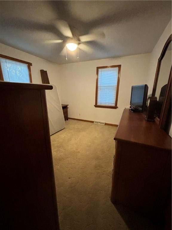 office with light carpet and ceiling fan