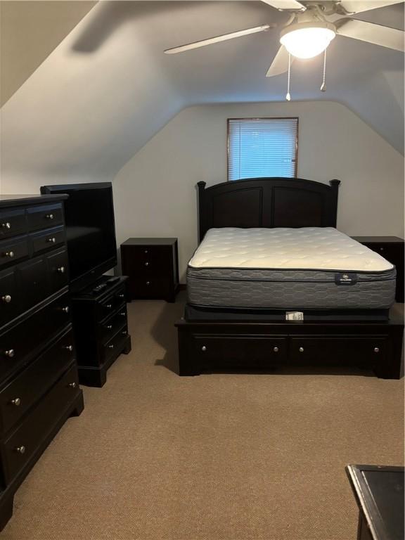 bedroom featuring ceiling fan, lofted ceiling, and light carpet