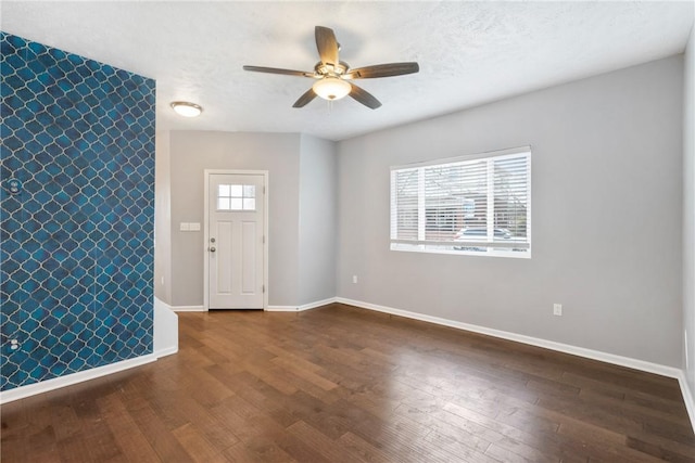 foyer entrance featuring ceiling fan, a healthy amount of sunlight, and dark hardwood / wood-style flooring