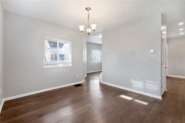 unfurnished dining area featuring dark hardwood / wood-style flooring and an inviting chandelier