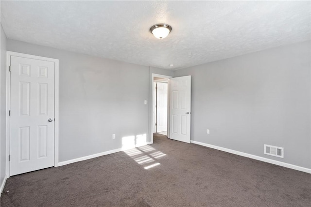 carpeted empty room with a textured ceiling