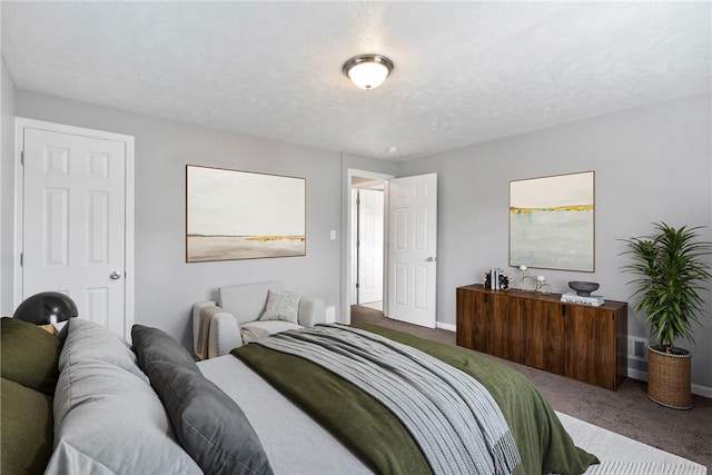 bedroom featuring dark carpet and a textured ceiling