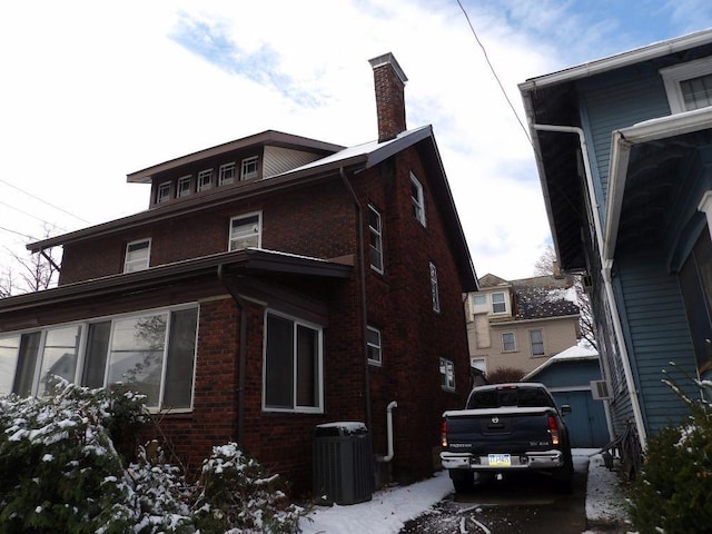 view of snow covered exterior with central AC