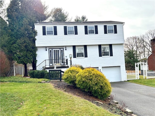 view of front of property with a garage and a front lawn