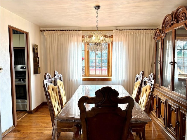 dining area featuring light wood-type flooring and an inviting chandelier