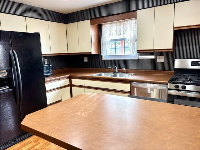 kitchen featuring sink, black appliances, and light hardwood / wood-style floors